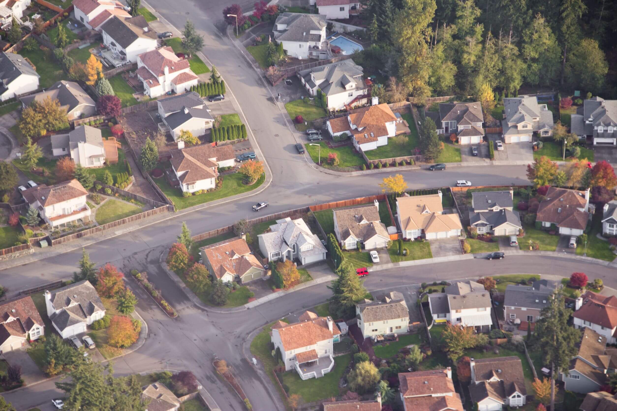 11268329-aerial-view-of-single-car-driving-on-a-neighborhood-road