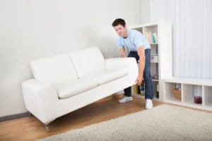 Man Moving A Couch Getting Ready to Move to New Apartment